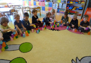Dzieci układają wieżę z kubeczków według wzoru.
